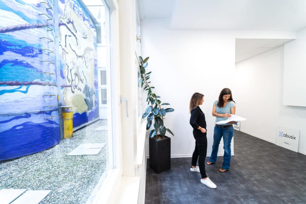 Two women standing in the office while talking