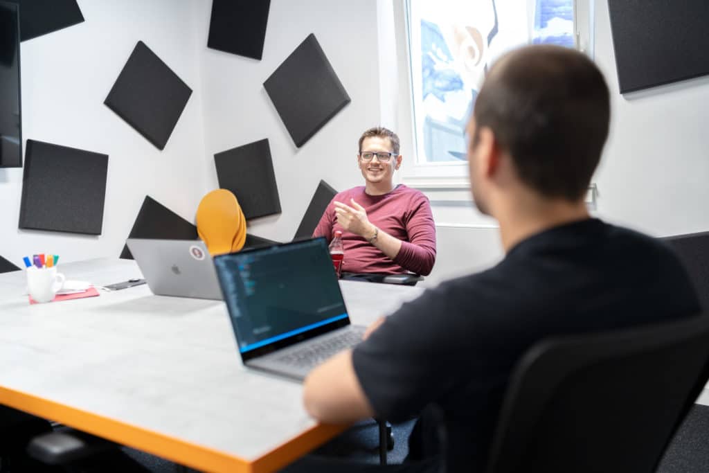 two guys discussing a topic in a meeting room