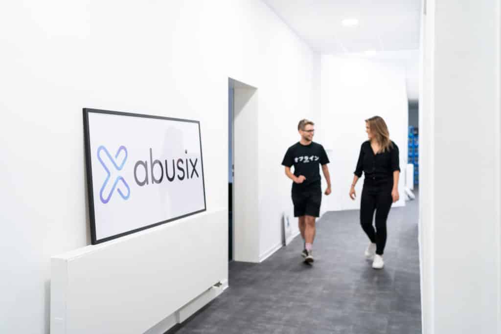 two people walking down the hallway in the abusix office
