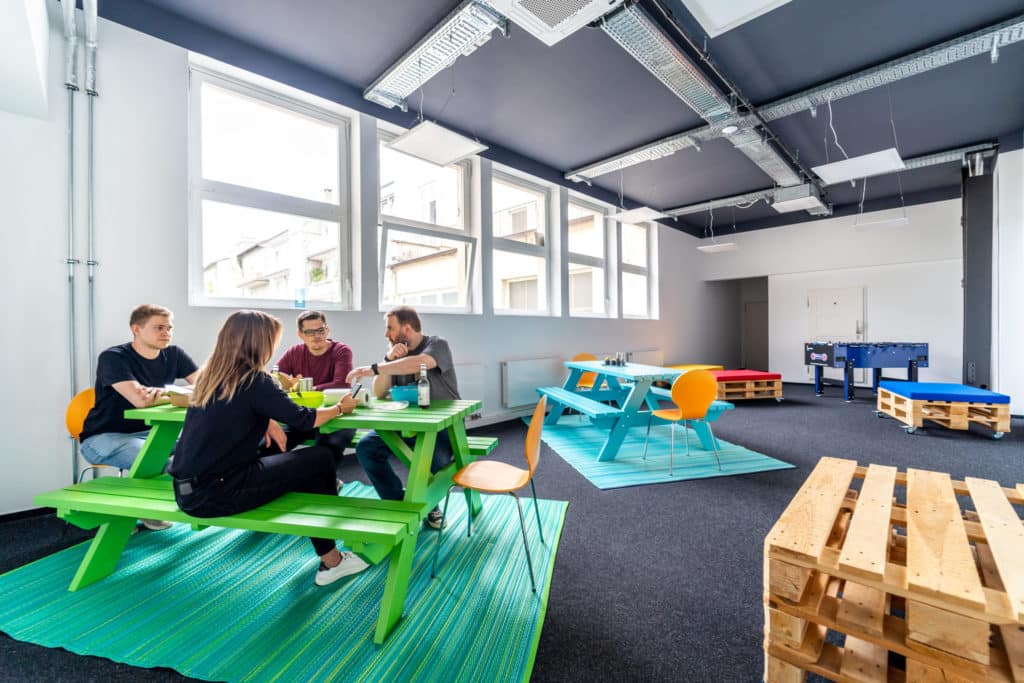 Lunch room in an office with four people sitting on a table