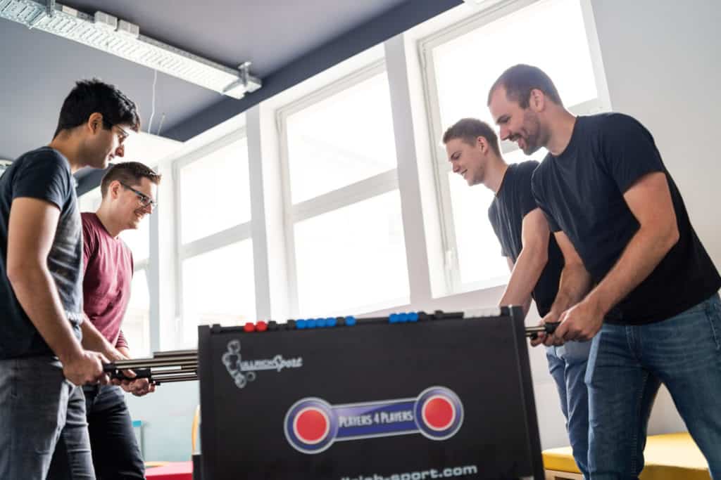 four guys playing foosball